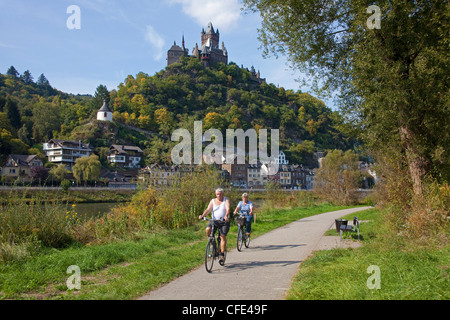 Radfahrer auf einem cycleway am Flußufer der Mosel, Cochem mit Schloss, Rheinland-Pfalz, Deutschland, Europa Stockfoto