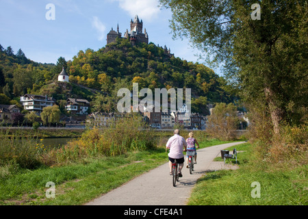 Radfahrer auf einem cycleway am Flußufer der Mosel, Cochem mit Schloss, Rheinland-Pfalz, Deutschland, Europa Stockfoto
