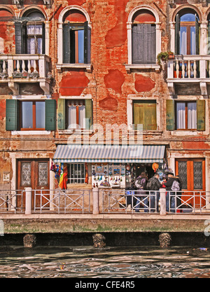 Venedig, alten Gebäude mit Blick auf das Wasser und die Touristen vor einem Souvenir-shop Stockfoto