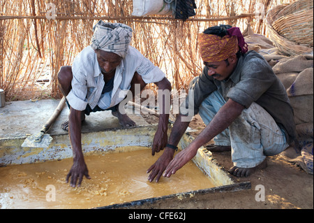 Jaggery Produktion im ländlichen Süden indischen Landschaft. Indien. Unraffiniertes Rohzucker in eine Kühlwanne vor dem Walzen. Stockfoto