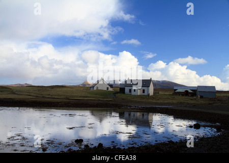 Ein Crofter Haus spiegelt sich im Wasser in der Bucht auf der Insel von Sanday (Canna), kleinen Inseln, Schottland Stockfoto