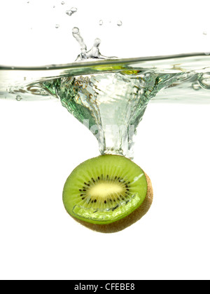 Kiwi-Scheibe spritzt ins Wasser über weißem Hintergrund Stockfoto