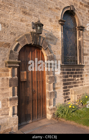 Close-up von außen Tür (Gibbs Surround) hölzerne Tür & halbrundes Bogenfenster-St Peter's Church, Addingham, West Yorkshire, England, UK. Stockfoto