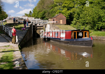 Sonnigen Bootsfahrt (Menschen stehen und beobachtete wie 15-04 aus der Unterseite Schleusenkammer Reisen) - fünf Aufstieg Schlösser, Bingley, Leeds Liverpool Canal, England. Stockfoto