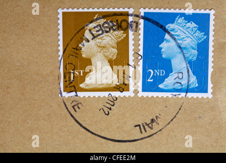Briefmarken der 1. Und 2. Klasse mit einem Kopf aus Queens auf einem braunen Umschlag und einer Poststelle von Royal Mail Dorset Stockfoto