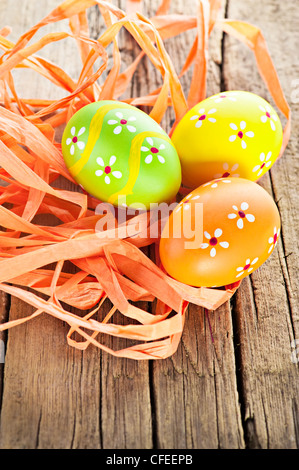 Ostern-Hintergrund. Makroaufnahme von bemalten Eiern und Band Dekoration auf alten hölzernen Textur Stockfoto