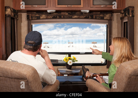 Junges Paar genießen Sie Blick auf den Strand von ihrer 5th Wheel RV. Stockfoto