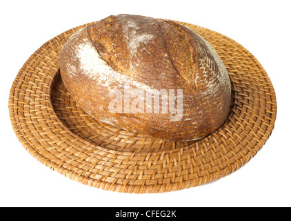 Frisch gebackenen Laib Sauerteig-Roggenbrot, isoliert auf weiss angezeigt auf Korbwaren Tablett isoliert auf weiss Stockfoto