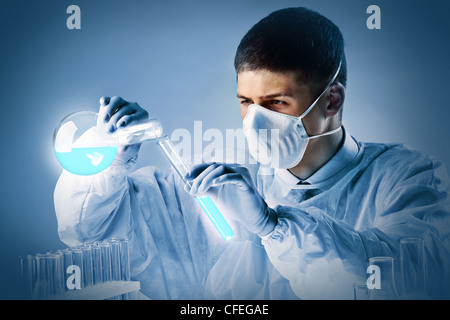 Junge maskierte Chemiker bereit, eine Chemikalie in anderen gießen Stockfoto