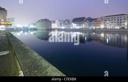 Blick auf Zürich und Altstadt reflektiert in der Limmat in der Nacht. Stockfoto