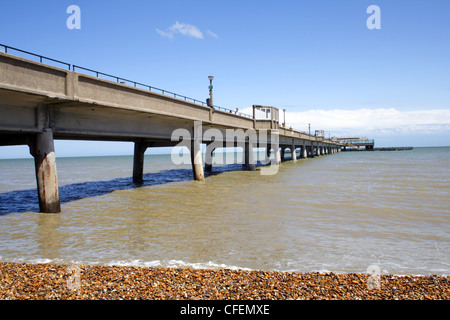 Der Pier am Deal, Kent, erstreckt sich in das Meer von einem Kieselstrand. Blauer Himmel. Stockfoto