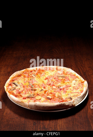 Pizza auf einem Holztisch Stockfoto