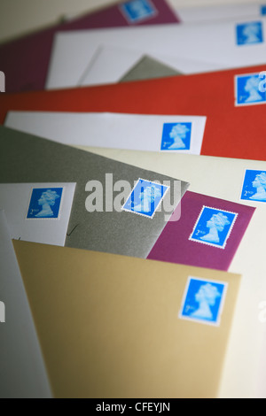 2. Klasse britische Briefmarken auf verschiedene farbige Umschläge Stockfoto