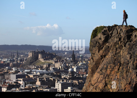 Ein Tourist auf Arthurs Seat mit Blick auf die Burg und die Skyline der Auld Reekie, Edinburgh, Schottland, Vereinigtes Königreich, Europa Stockfoto