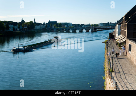 Lastkahn auf der Maas, St.-Servatius-Brücke und Kaffeebars am Maaspuntweg am Flussufer, Maastricht, Limburg, Niederlande Stockfoto