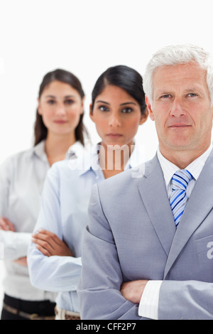 Nahaufnahme eines Geschäftsmannes mit zwei Frauen hinter ihm Stockfoto