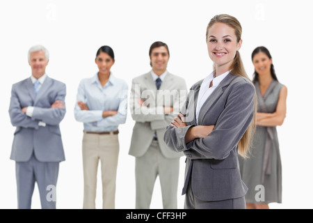 Blonde Frau mit Geschäftsleuten hinter ihr Stockfoto