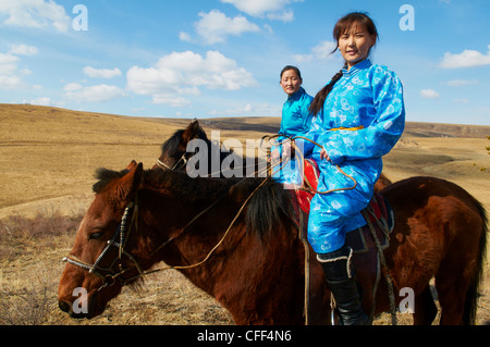 Junge mongolische Frauen in traditioneller Tracht (Deel) reiten Pferde, Provinz Khovd, Mongolei, Zentral-Asien, Asien Stockfoto