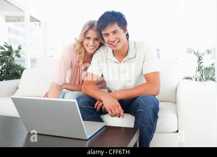 Mann und Frau freut sich und Lächeln, als sie zusammen auf der Couch sitzen Stockfoto