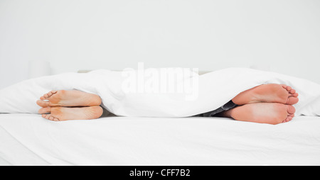 Mann und Frau die Füße in einem Bett von einander abgewandt Stockfoto