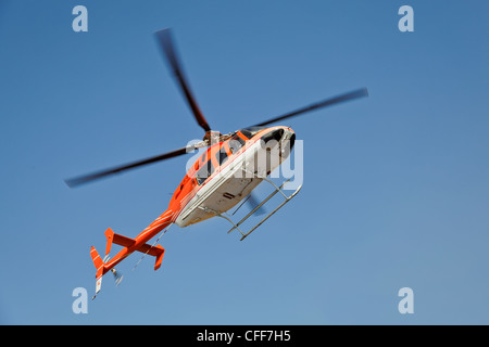 orange-weiße Hubschrauber in klaren, blauen Himmel schwebt Katra Heliport im nördlichen indischen Himalaya, Foto-Wiedergabe Stockfoto