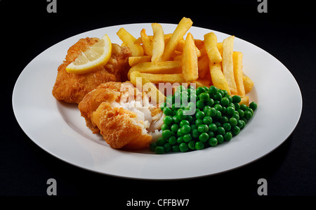 Nahaufnahme von Fish And Chips mit Erbsen und einer Scheibe Zitrone. Ein traditionelles Gericht der britischen Küste Stockfoto