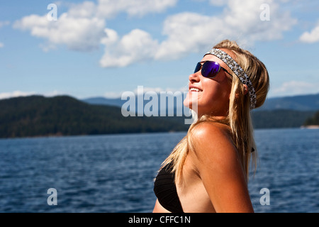 Eine sportliche junge Frau lächelt während des Subathing weiter zu einem See in Idaho. Stockfoto