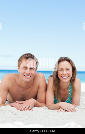 Lächelnde paar am Strand liegen Stockfoto