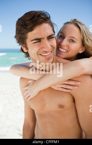 Junge Frau umarmt ihr Freund im stehen am Strand Stockfoto