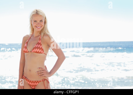 Frau, Lächeln, als sie steht mit einer auf ihre Hüfte Hand Stockfoto