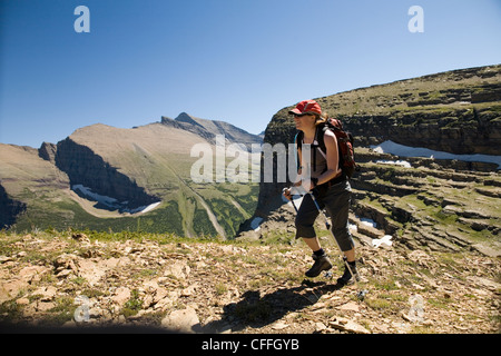 Eine Frau in ihren frühen dreißiger Jahren Wanderungen entlang des Weges Grinnell Gletscher im Glacier National Park, Montana. Stockfoto