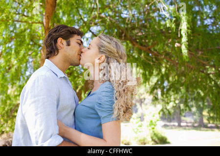 Seitenansicht von ein paar küssen unter einem Baum Stockfoto