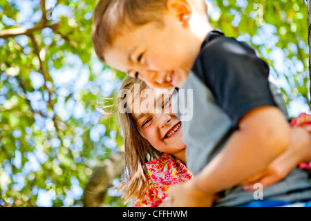 Ein Junge und ein Mädchen klettert einen Baum in Garden City, Utah. Stockfoto