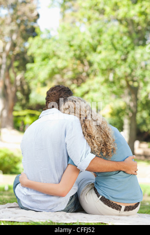 Rückansicht des ein paar sitzen auf dem Rasen Stockfoto