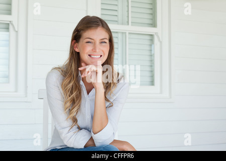 Eine lächelnde Frau mit einer Hand am Kinn Stockfoto