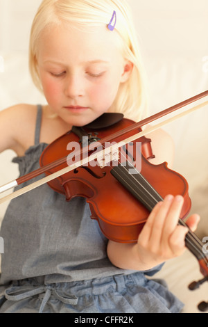 Süßes junge Mädchen spielt leise Geige Stockfoto