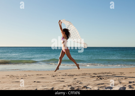 Attraktive Frau im Bikini mit einem Sarong springen Stockfoto