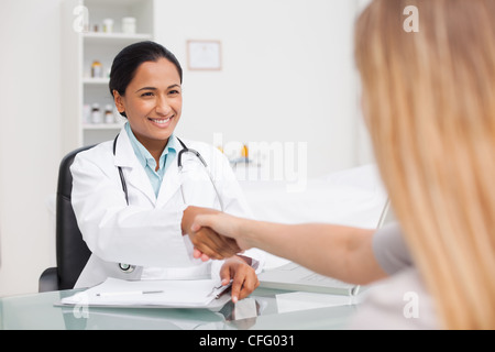 Lächelnd, Arzt und ihrer Patientin, die Hände schütteln Stockfoto