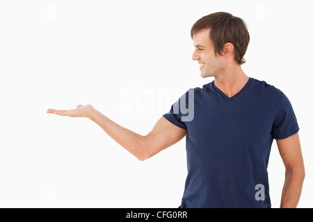 Lächelnd Mann stehend mit Hand mit der Handfläche oben Stockfoto