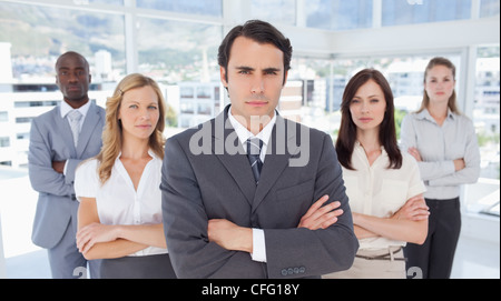 Ernsthaften Geschäftsmann stand vor seinen Kollegen Stockfoto