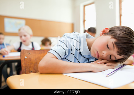 Müde Schüler Rast an seinem Schreibtisch Stockfoto