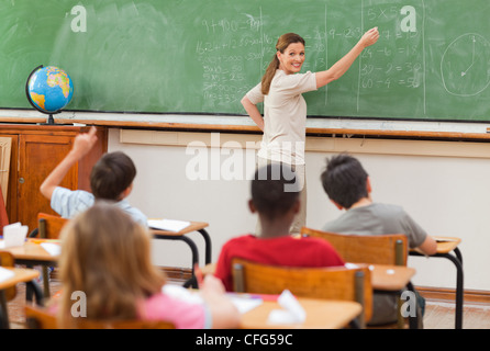 Lächelnde Lehrer an Tafel schreiben Stockfoto