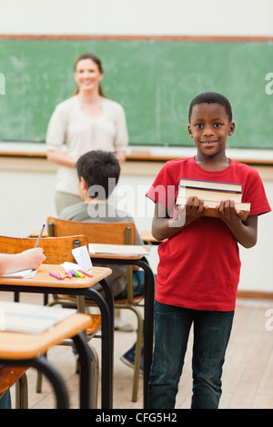 Lächelnd Schüler halten Stapel Bücher Stockfoto