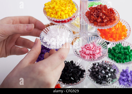 Kleines blondes Mädchen mit Hama-Perlen zu spielen Stockfoto