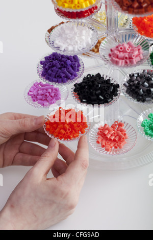 Kleines blondes Mädchen mit Hama-Perlen zu spielen Stockfoto