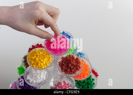 Kleines blondes Mädchen mit Hama-Perlen zu spielen Stockfoto