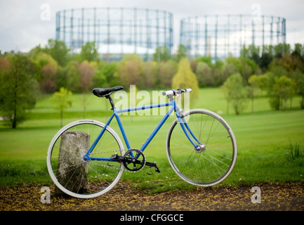 Ein blau-weißen festen Rad Fahrrad in einem Park im Herbst vor Gas-Türme Stockfoto