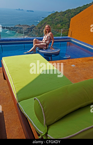 Eine junge Frau in einem Las Brisas Ixtapa Resort deluxe Zimmer Terrasse Pool in Ixtapa/Zihuatanejo, Mexiko Stockfoto