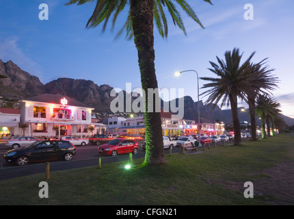 Restaurants und Bars entlang der Victoria Road in Camps Bay in der Nacht. Cape Town. Südafrika Stockfoto