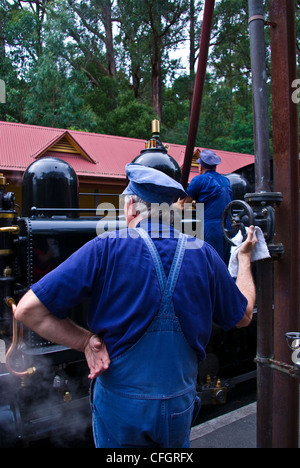 Eine antike Dampf Zugpersonal füllt einen Motor-Kessel mit Wasser. Stockfoto